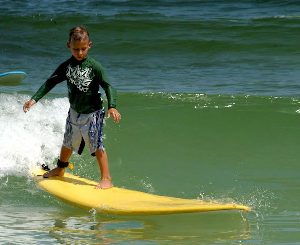 Kids at summer surf camp riding waves at Jupiter Beach